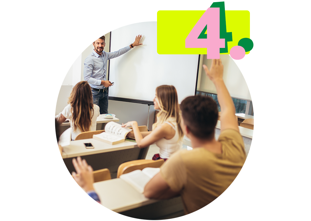 Eine Gruppe sitzt in einer Klasse und folgt den Ausführungen eines Lehrers, der an einem Whiteboard steht.
