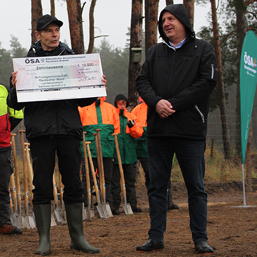 Vorstand Reiner Bülow überreicht Scheck für Baumpflanzaktion